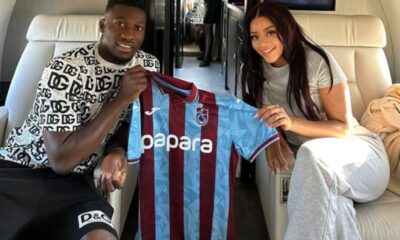 Andre Onana and wife Melanie Kamayou pictured holding a Trabzonspor shirt on a private jet