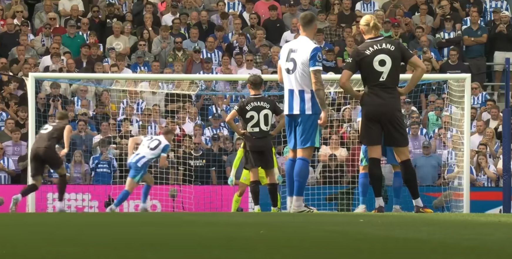 James Milner pictured stepping up for a penalty kick for Brighton against Manchester City in August 2025 as Erling Haaland watches on