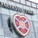A general photo of the Tynecastle Park sign and Hearts badge