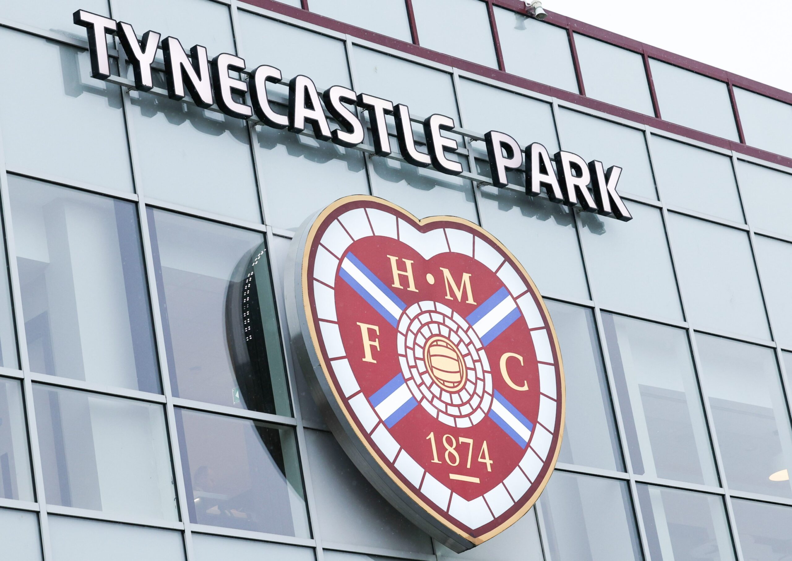 A general photo of the Tynecastle Park sign and Hearts badge