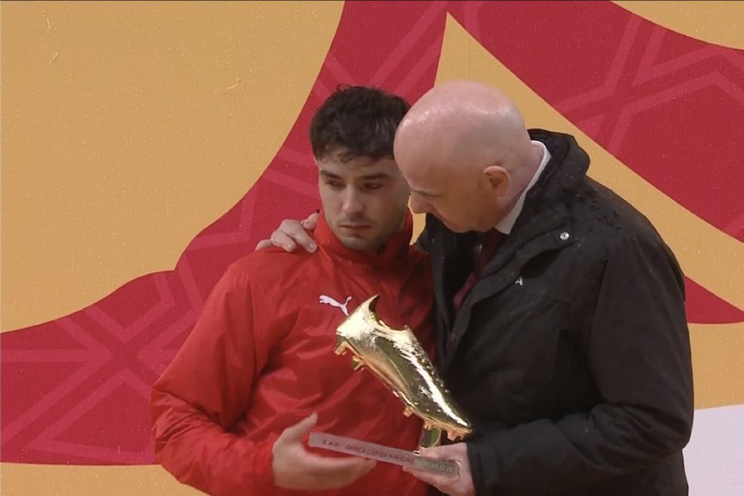 Brahim Diaz pictured looking sad due to penalty miss while collecting the AFCON 2025 Golden Boot trophy from FIFA president Gianni Infantino