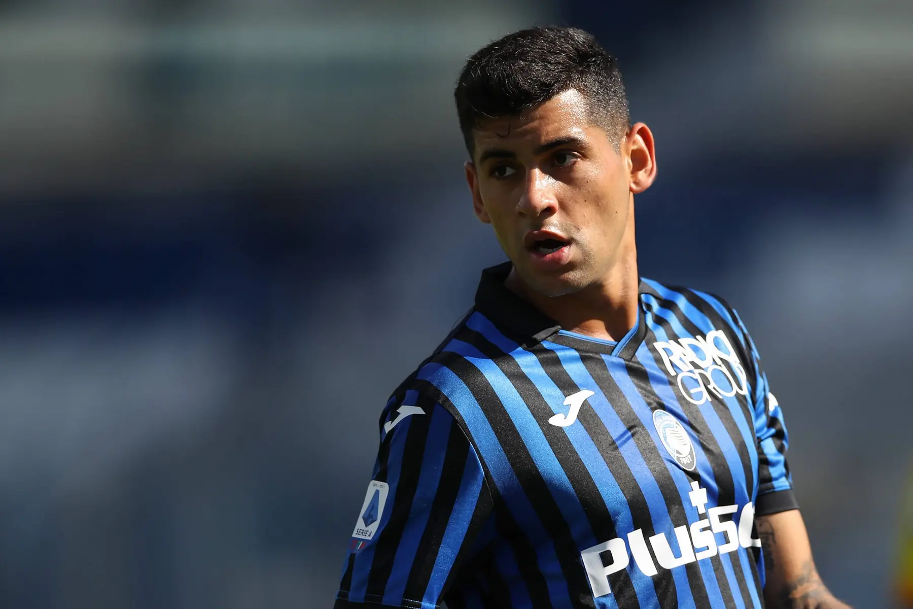 Cristian Romero in Atalanta's blue and black striped jersey during a match.