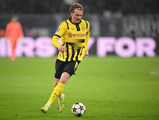 Julian Brandt in Borussia Dortmund kit dribbling the football during a match.