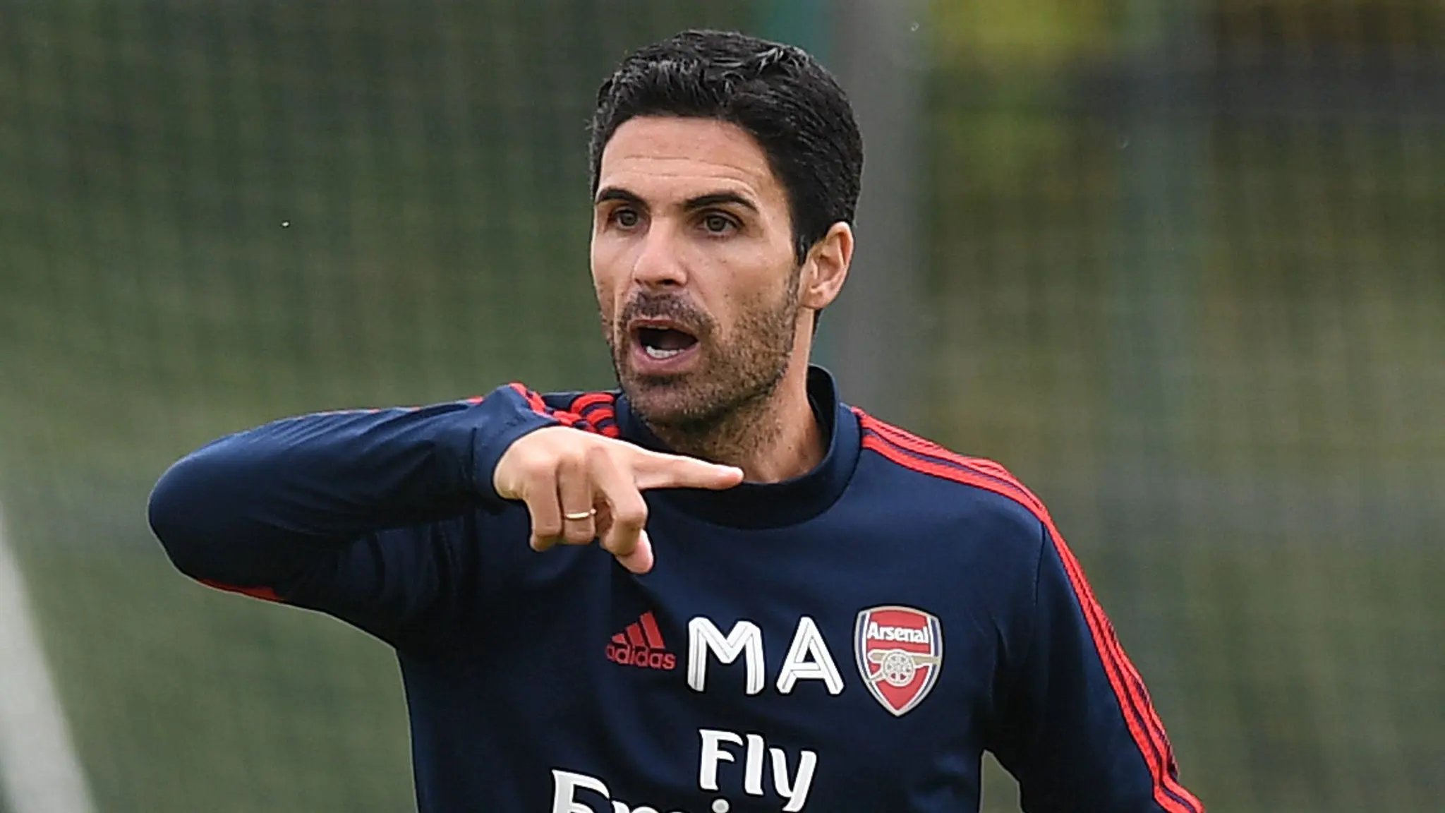 Mikel Arteta gesturing during a training session for Arsenal FC in coaching attire.