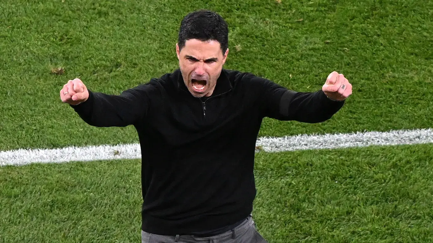 Mikel Arteta celebrating passionately on the sidelines during a match.